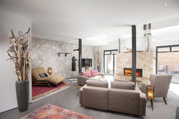 Wohnzimmer mit verschiedenen Sitz- und Liegemöglichkeiten modern gehalten