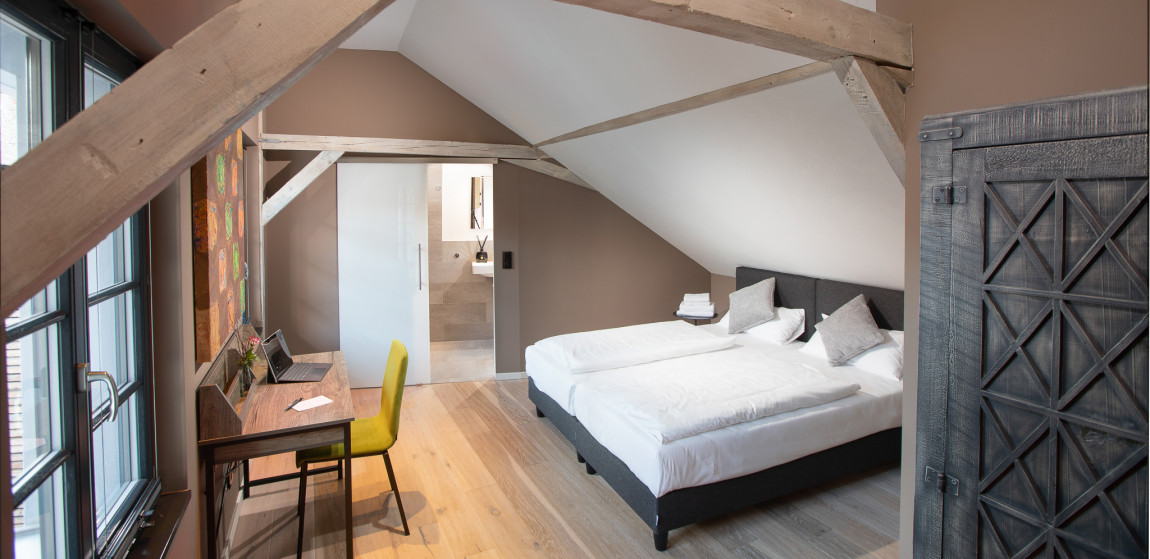 Schlafzimmer in der gemütlichen Dachschräge in warmen Farbtönen